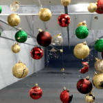 A room with many christmas ornaments hanging from the ceiling.