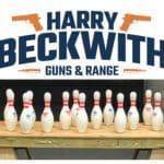 A table with bowling pins and guns on it.
