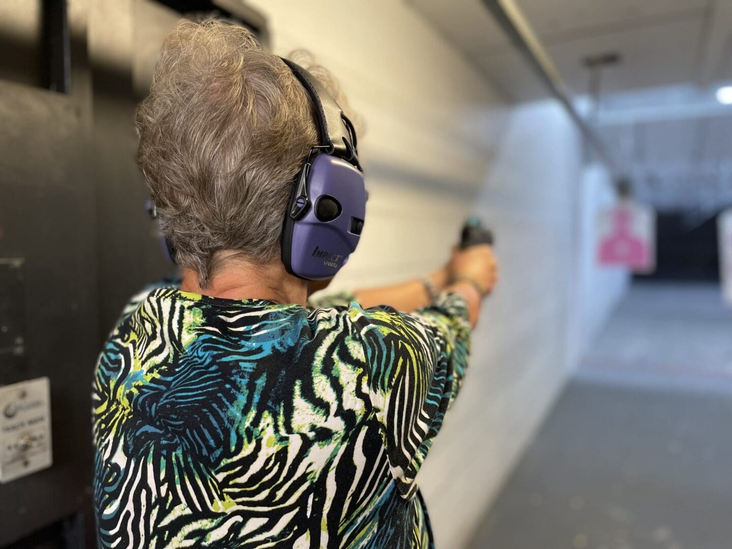 A woman wearing headphones and holding a gun.