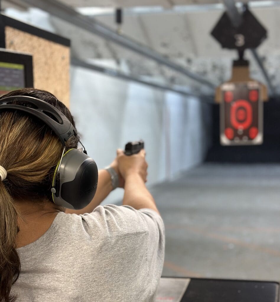 A woman wearing headphones and holding a gun