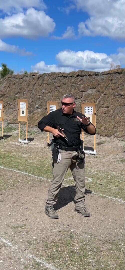 A man holding a gun in front of several targets.
