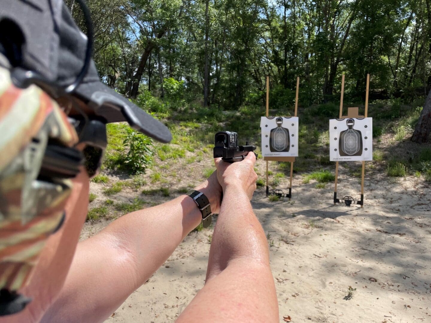 A person is holding their gun up to the target.