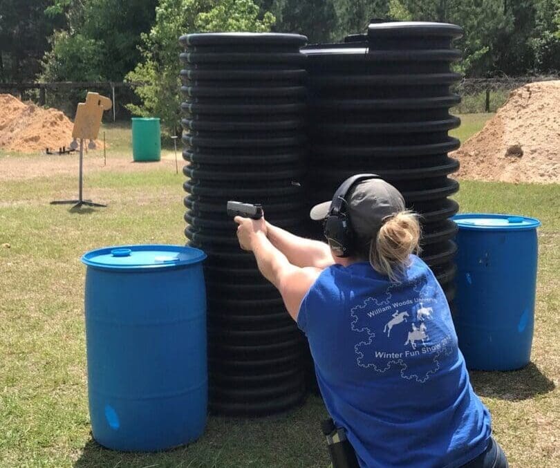 A woman is holding a gun in her hand