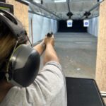 A man is holding his gun up to the side of the target.