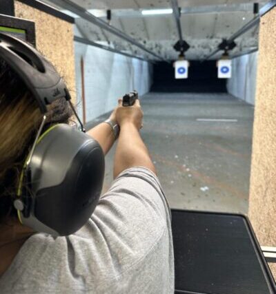 A man is holding his gun up to the side of the target.