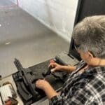 A man working on an old typewriter in a room.