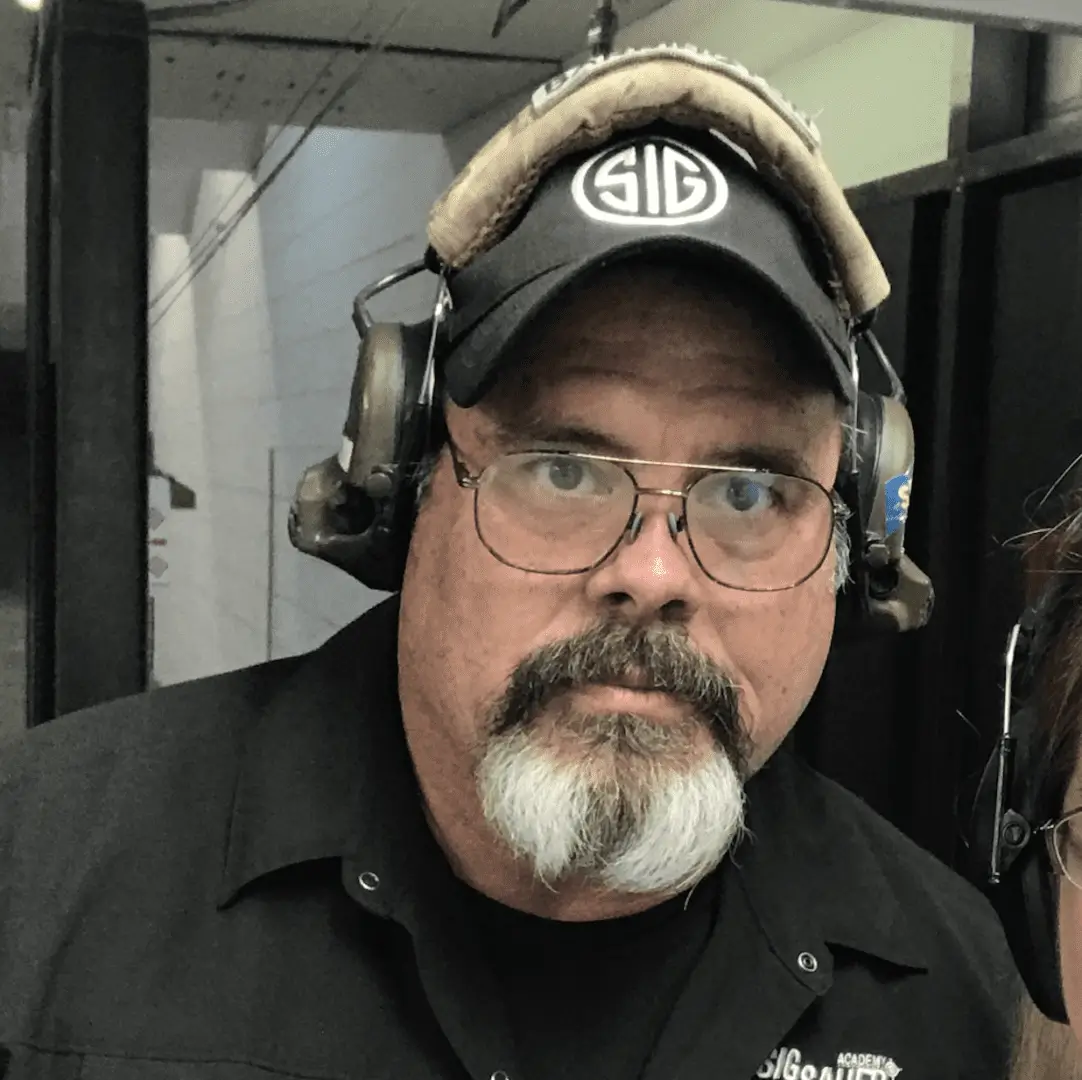 A man with glasses and beard wearing headphones.
