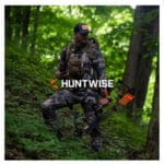 A picture of a man in the woods with his gear. Description saying "Hunt Wise"
