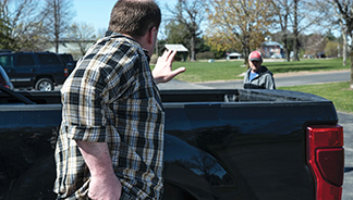 A man is approaching another man near his truck.
