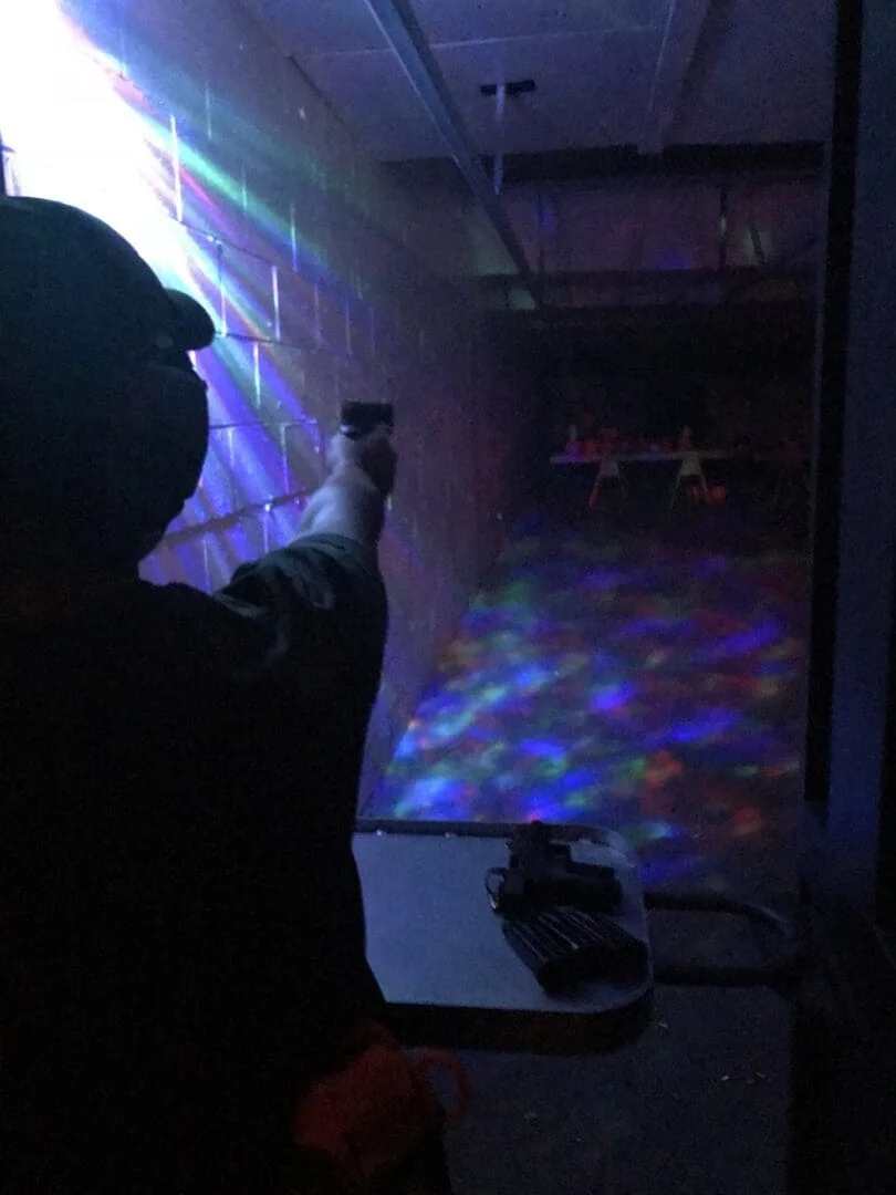 A person holding a remote control in front of a wall.