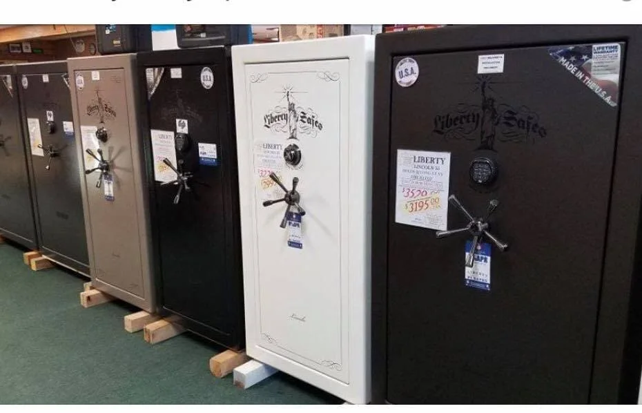 A white safe sitting in front of some other black and brown cabinets.